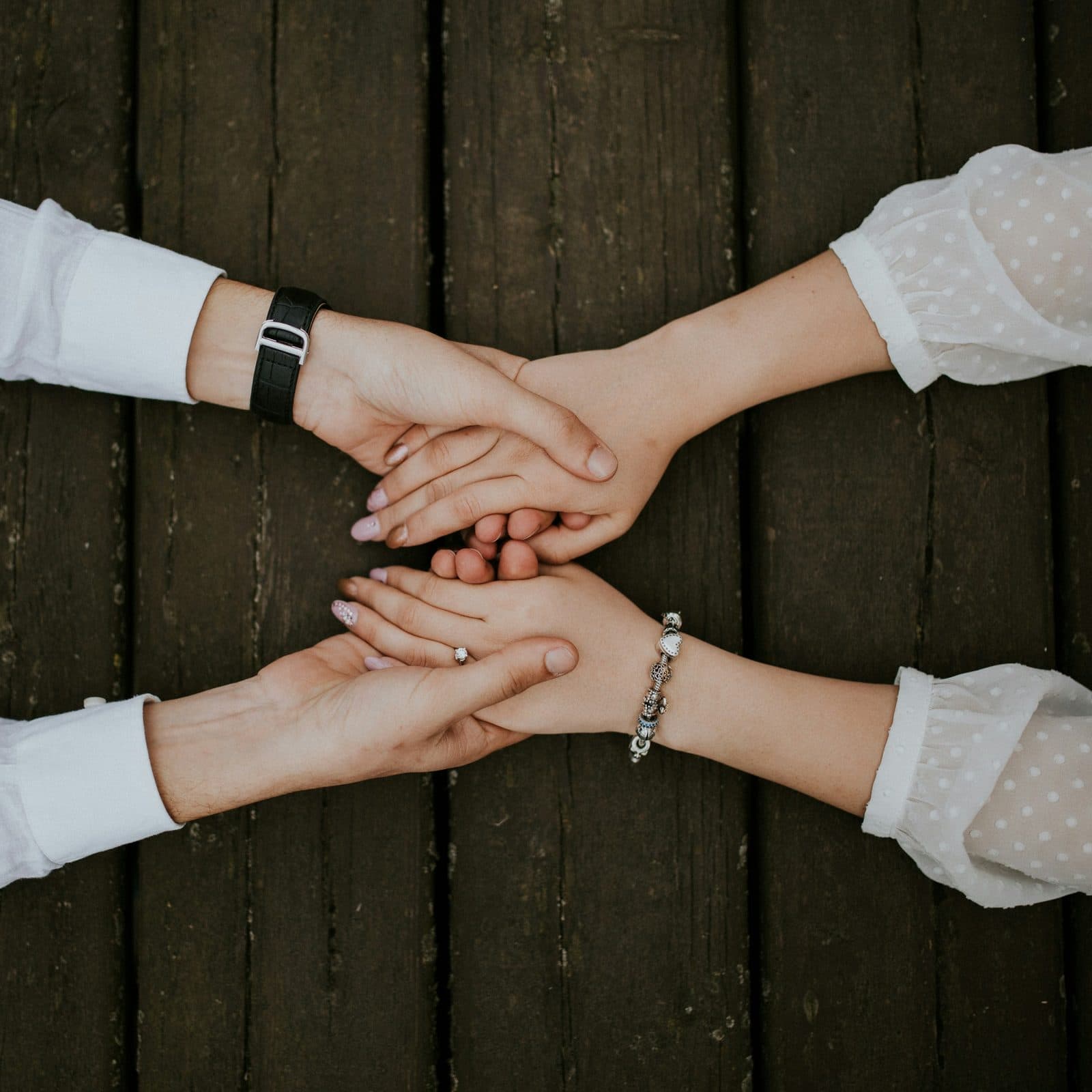 Two people holding hands in a gesture of support
