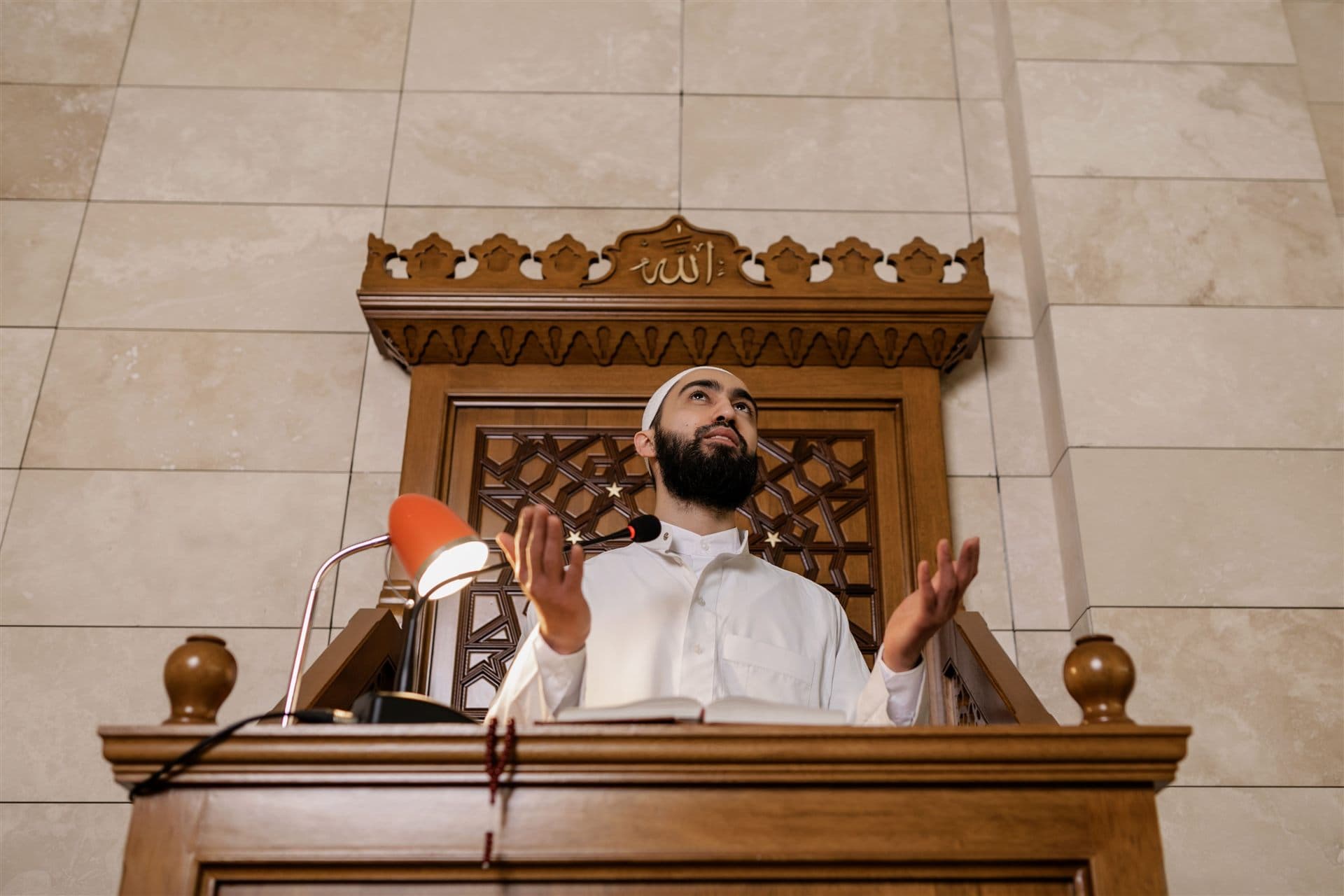 An imam making dua from the minbar