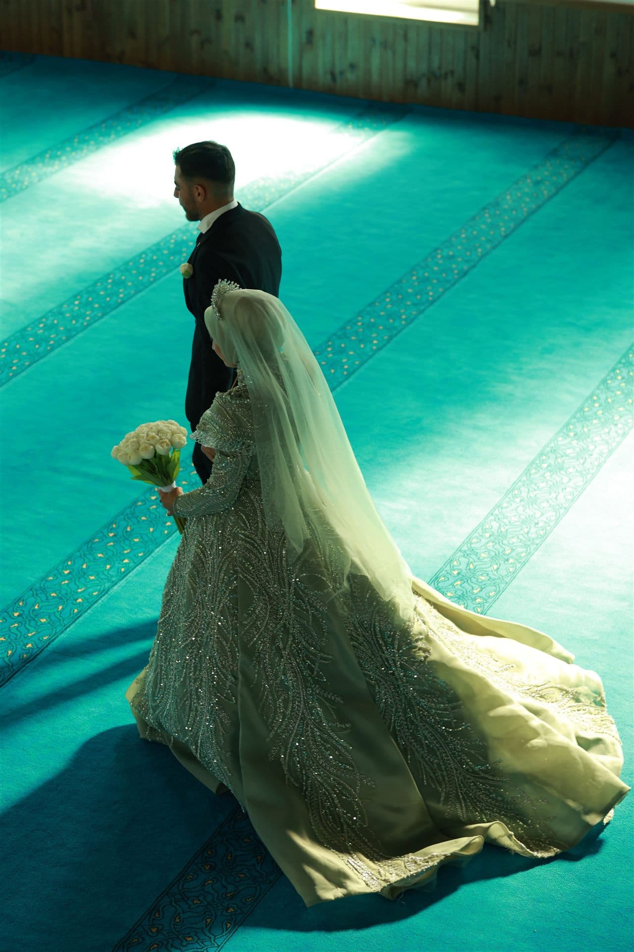A bride and groom walking through a mosque after their nikah